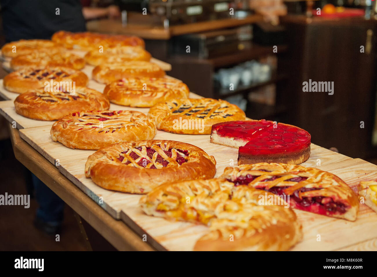 Different types of pies in pastry shop on the wooden display. Selective