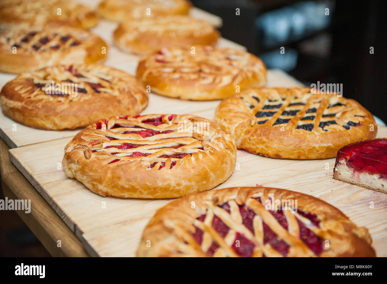 Different types of pies in pastry shop on the wooden display. Selective