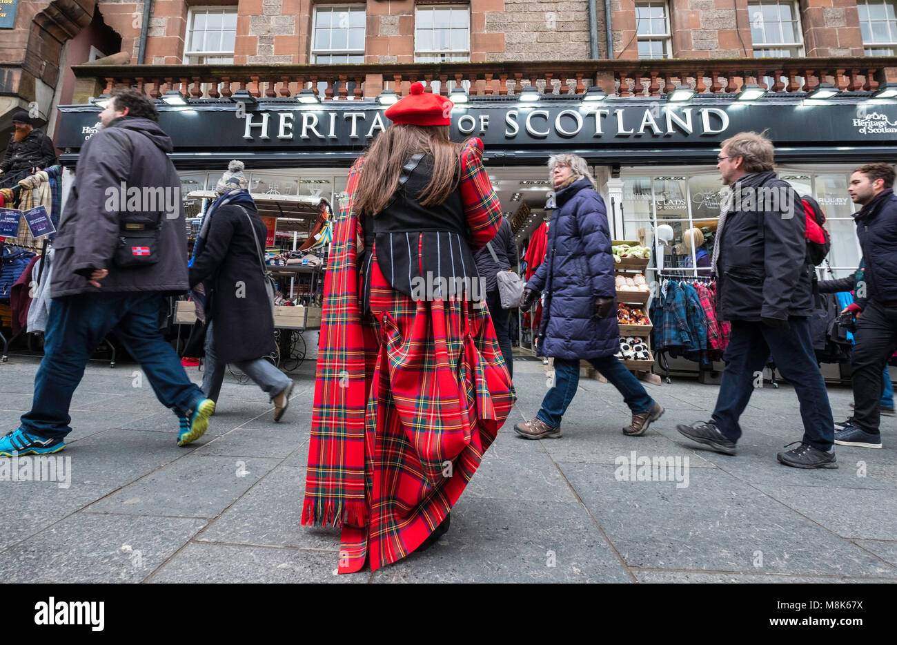 Woman wearing tartan handing out flyers to tourists at tourist gift shop on the Royal Mile in Edinburgh, Scotland, united Kingdom Stock Photo