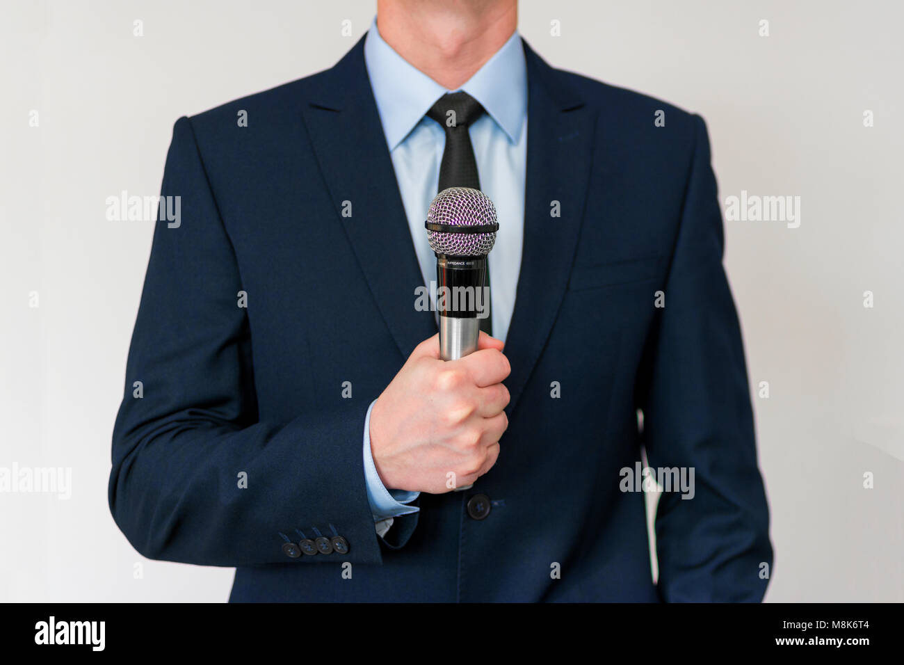 Man in suit holding a microphone hi-res stock photography and images ...