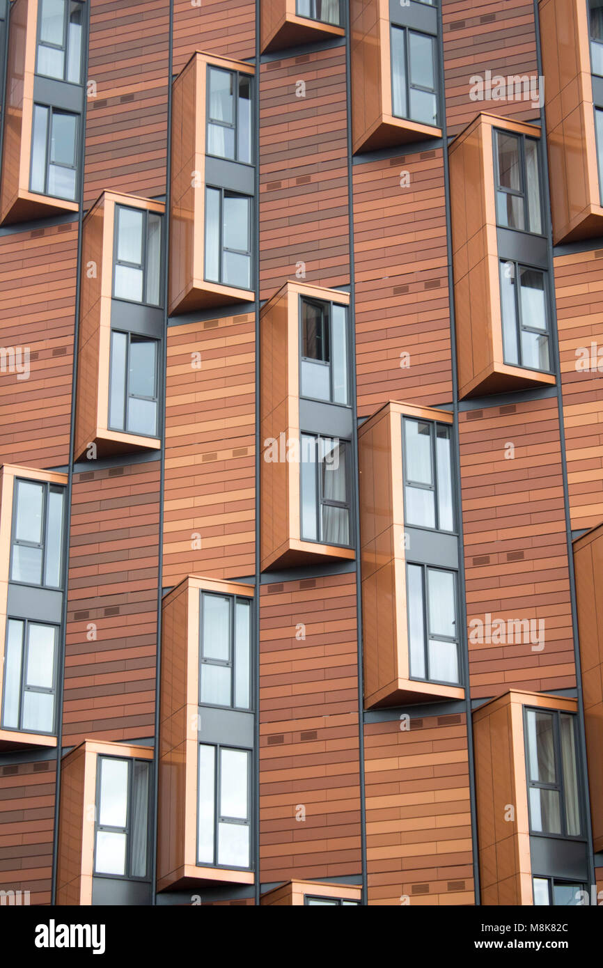 modern brown wood apartment/flat building with creative art glass windows in london, near wembley stadium Stock Photo