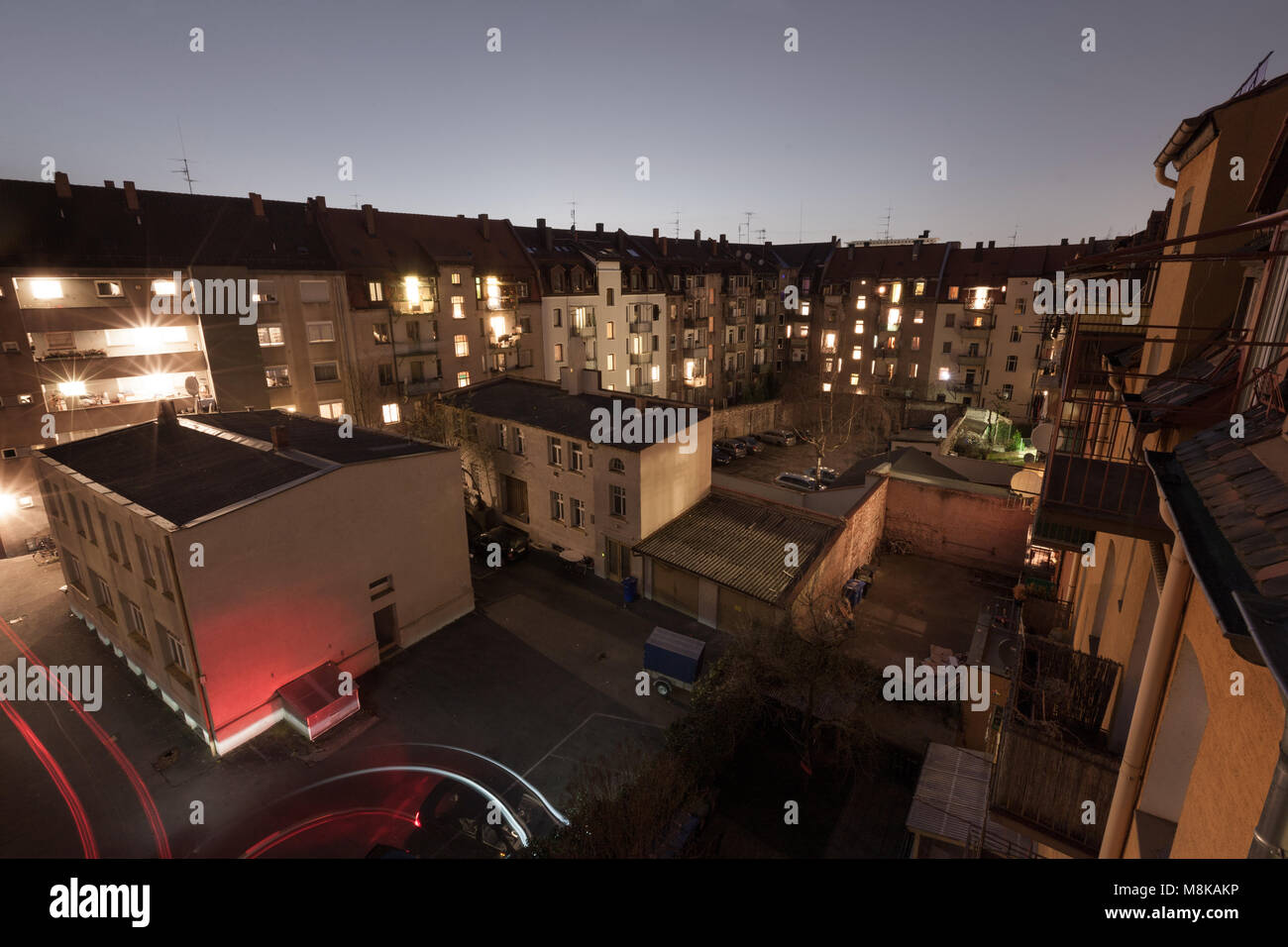 Backyard in Nuremberg (Nürnberg), Bavaria, Germany after sunset. The roofline of the tenement buildings is still back-lit by faint diffuse light. Stock Photo