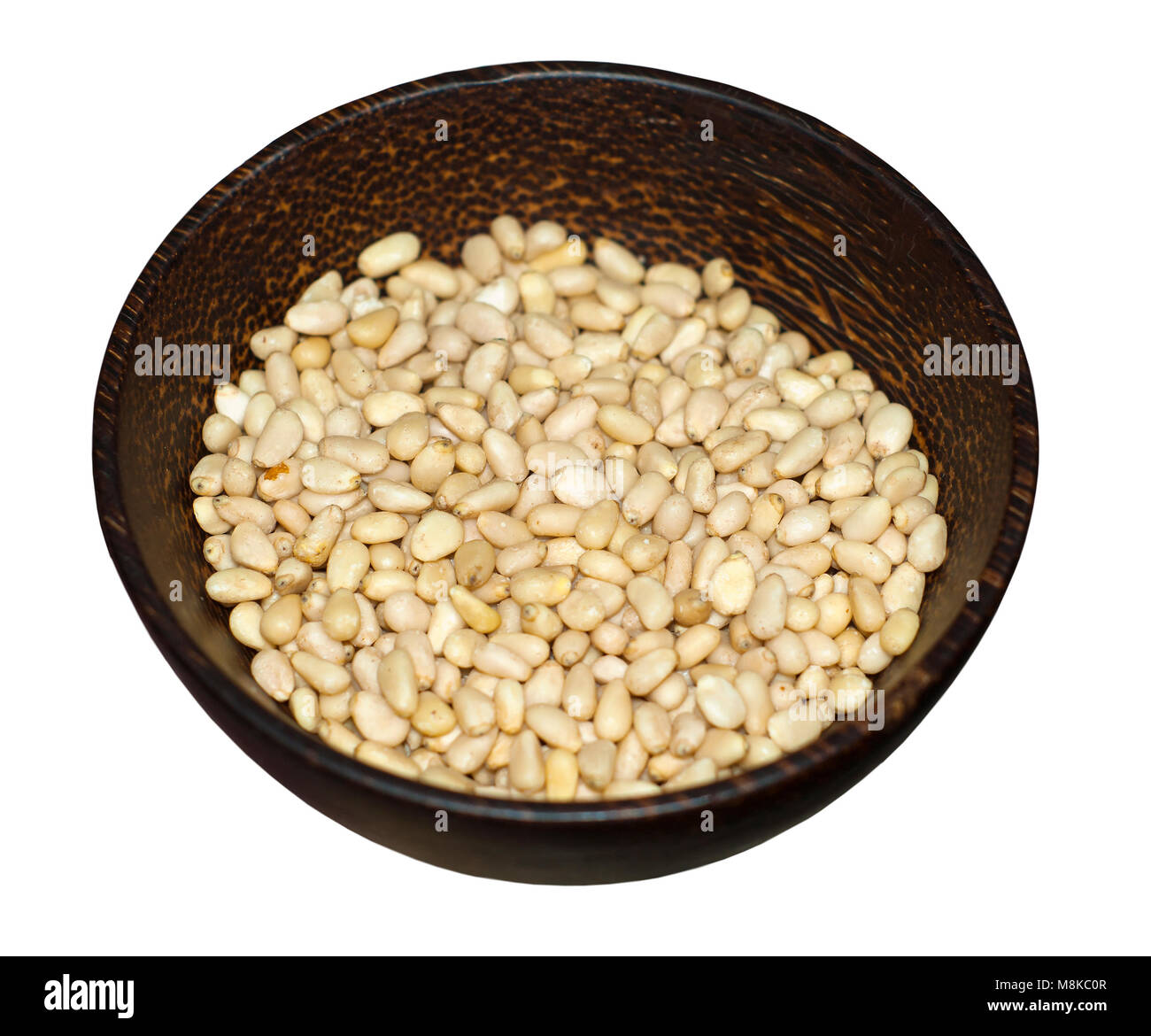 peeled pine nuts in a wooden cup isolated on a white background Stock Photo