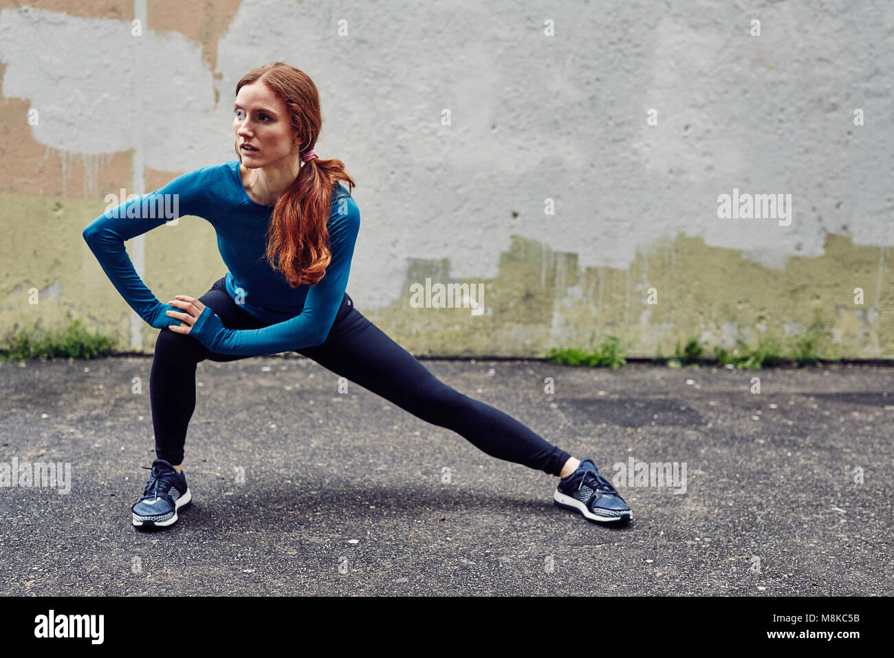 Young Caucasian Woman stretches before a Run Stock Photo