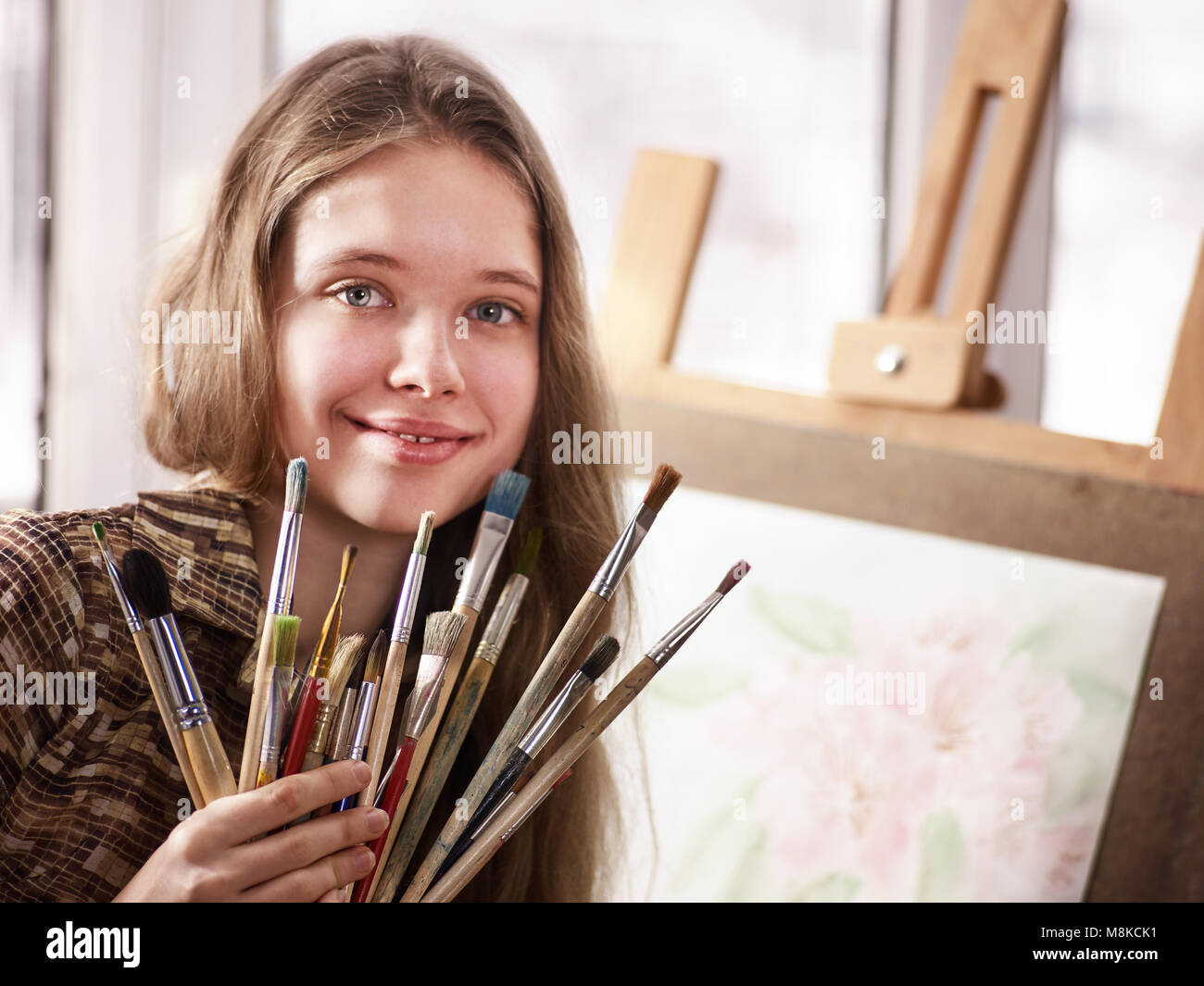 Artist painting on easel in studio. Girl paints with brush Stock Photo ...