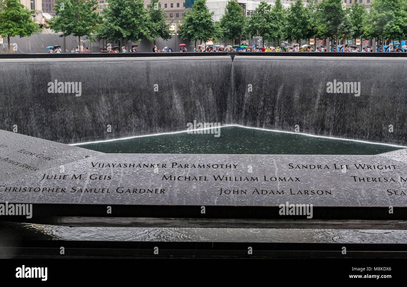 People stand at the South Memorial Pool at The 9/11 Memorial Site in Manhattan , location of the Twin Towers attack on September 11,2001 New York Stock Photo