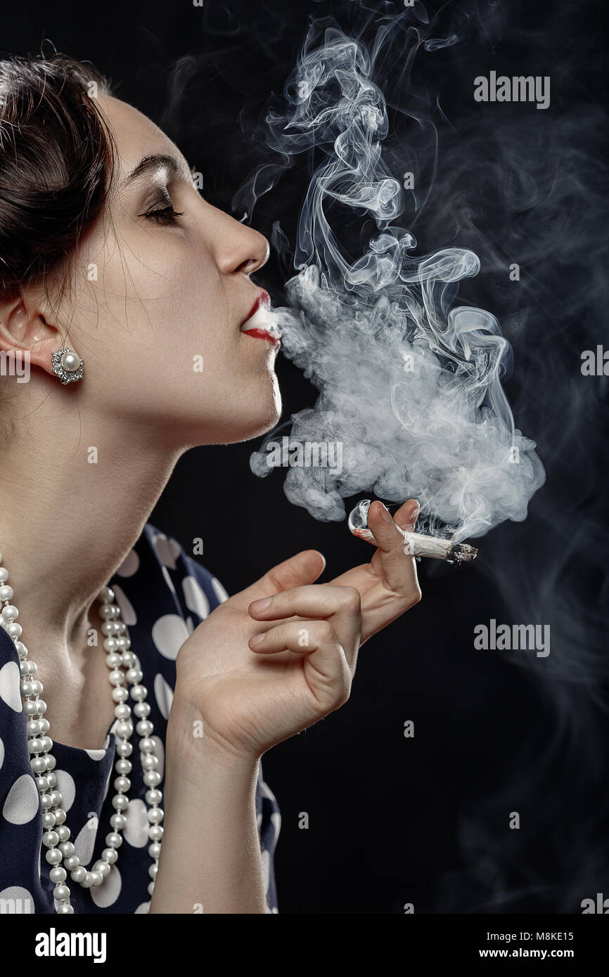 blond young woman smoking joint on black background Stock Photo Alamy