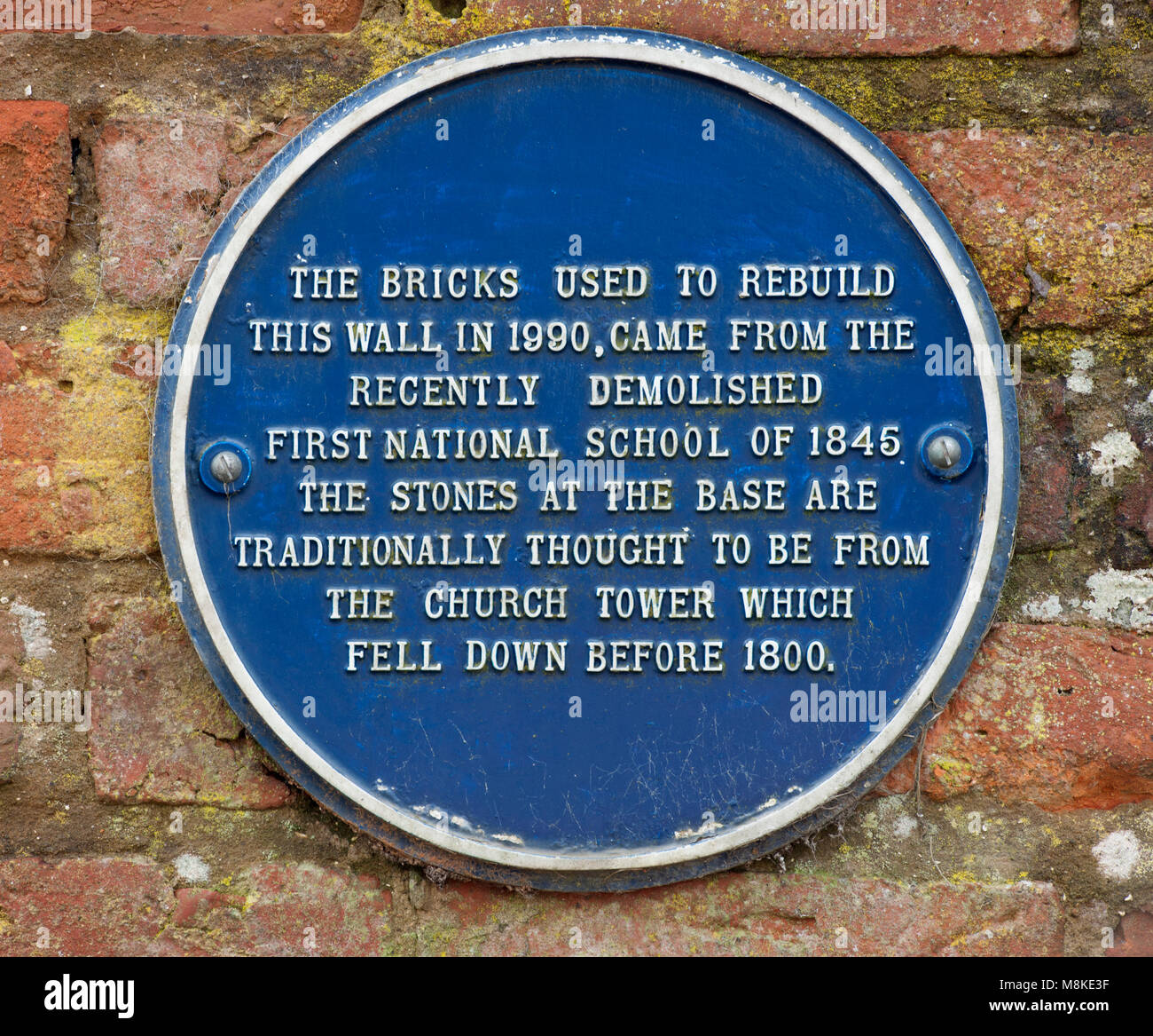 Blue plaque on the brick wall at St Oswald's parish churchyard, Church Street, Flamborough, Yorkshire, England, UK. Stock Photo