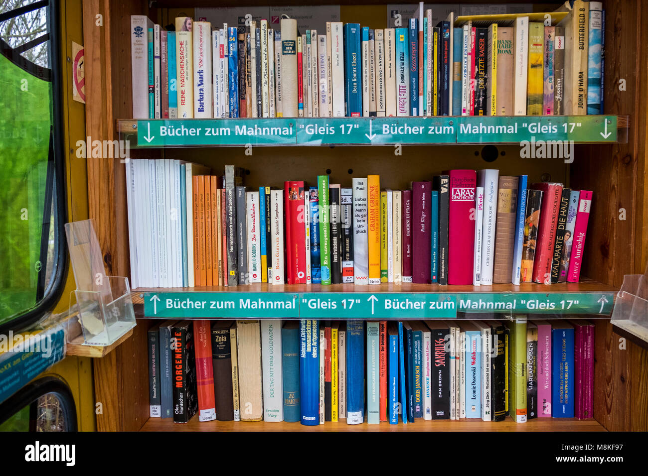 Berlin-Grunewald.Telephone kiosk,BücherboXX,book box. A small ‘honesty library’ with books.A shelf has books relating to the Gleis 17 memorial. Stock Photo
