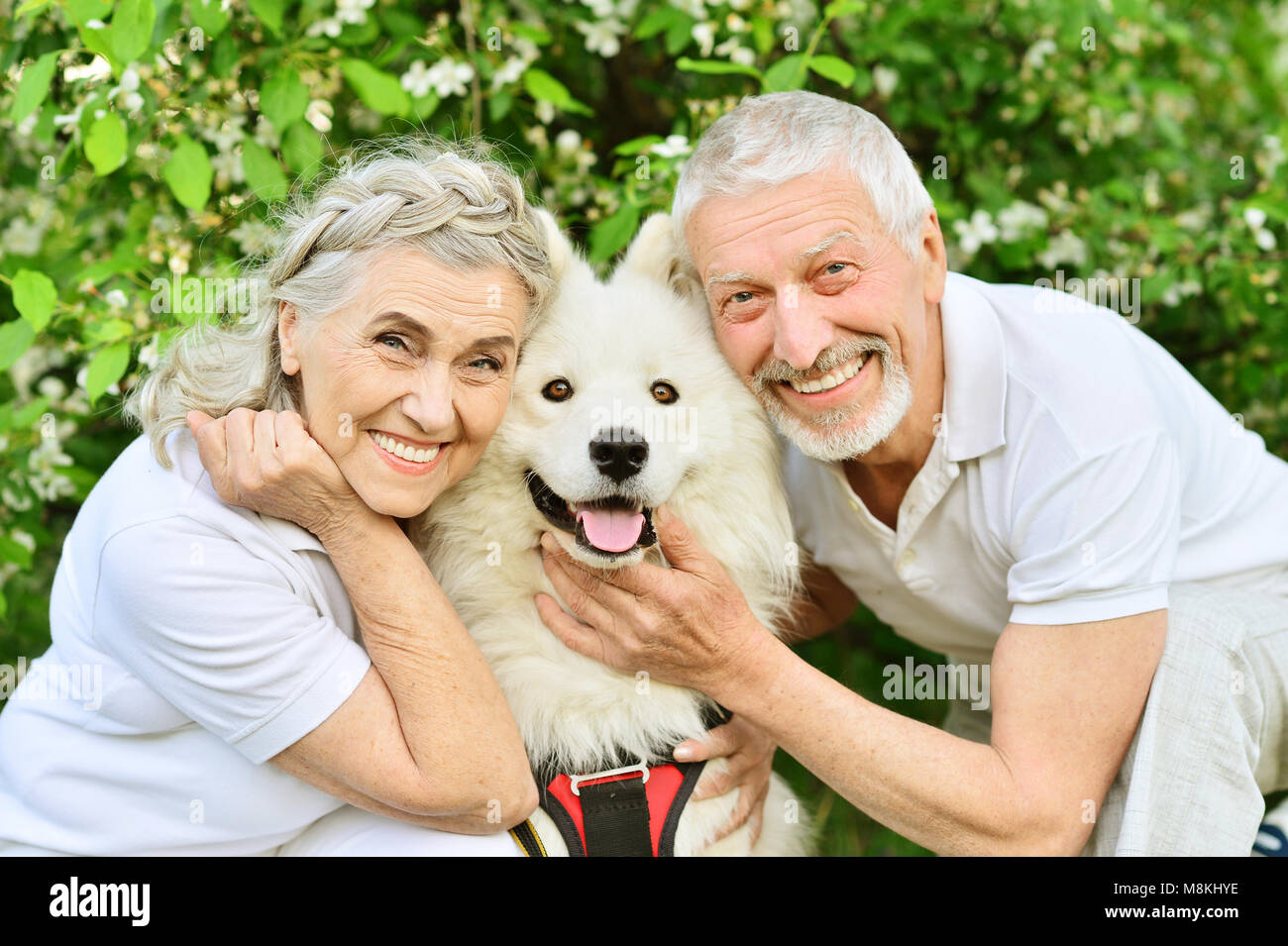 Happy couple hugging dog Stock Photo - Alamy