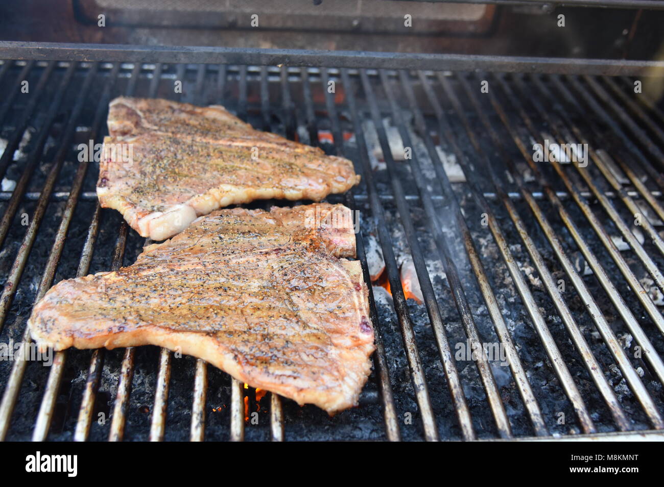 Delicious peppered TBone steaks on the grill Stock Photo Alamy