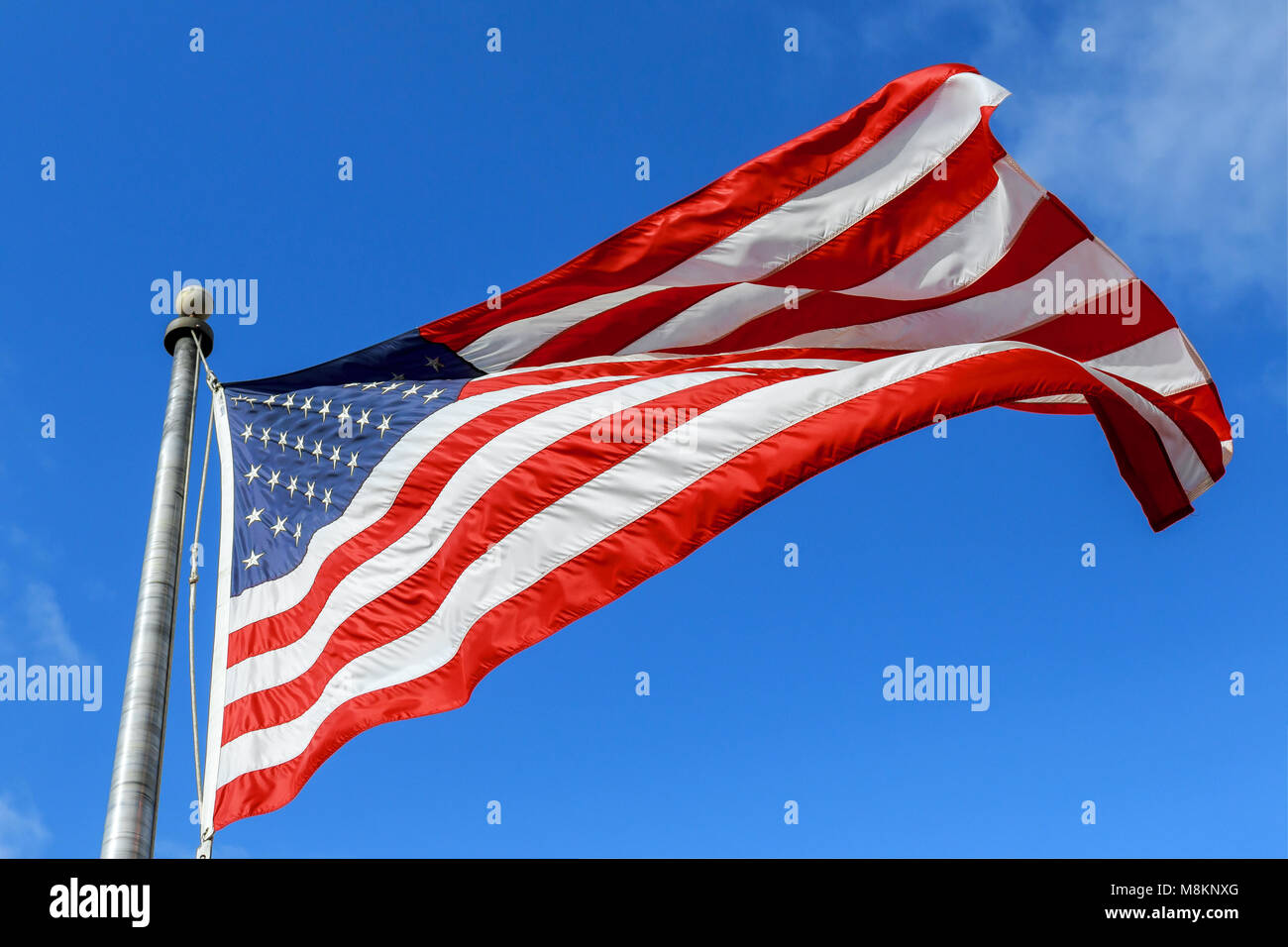 USA flag waving against clear blue sky on bright sunny day Stock Photo ...