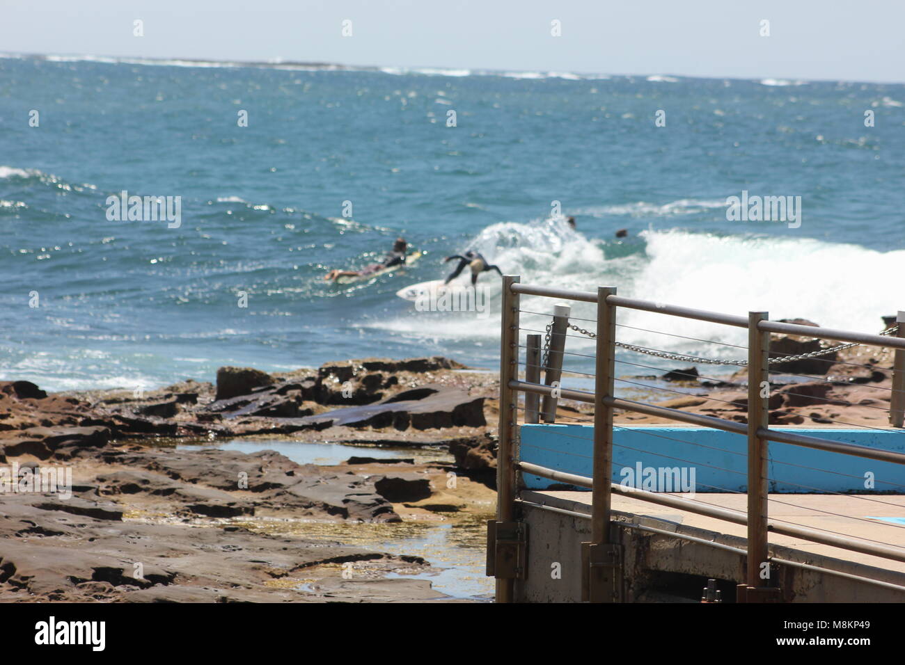 Surfing by an outdoor ocean pool Stock Photo Alamy