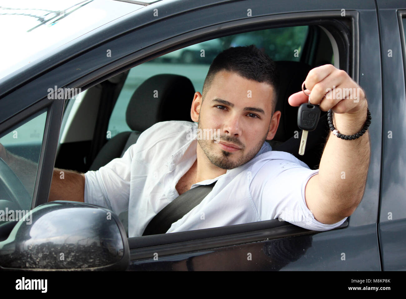 happy young man showing a key from car Stock Photo