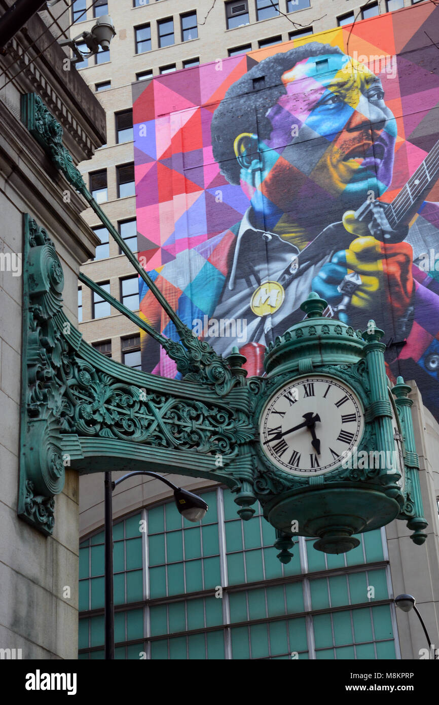 The over 100-year-old Marshall Fields clocks and a more recent mural of Blues great Muddy Waters on State Street in Chicago. Stock Photo