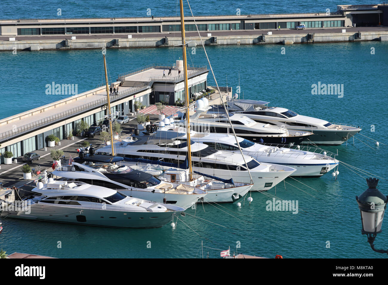 Monte-Carlo, Monaco - March 17, 2018: Luxurious Yachts And Megayachts Lined Up In The Monte-Carlo Harbour (Port Hercule), French Riviera Stock Photo