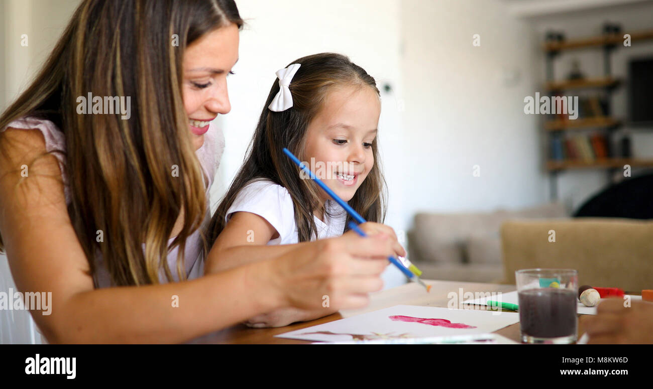 Little girl painting with her mother at home Stock Photo - Alamy