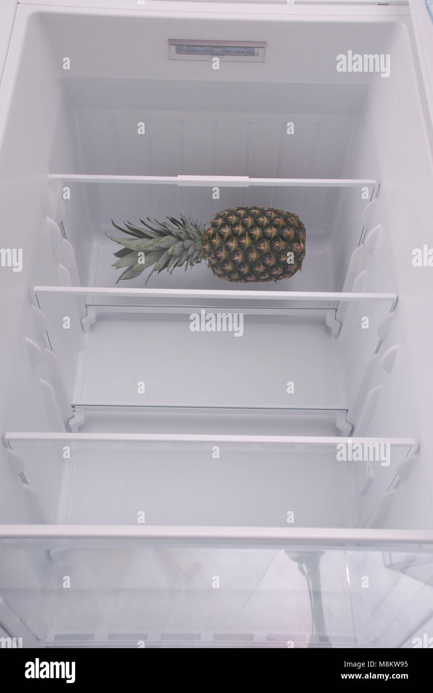 Pineapple inside in empty clean refrigerator with opened door Stock Photo