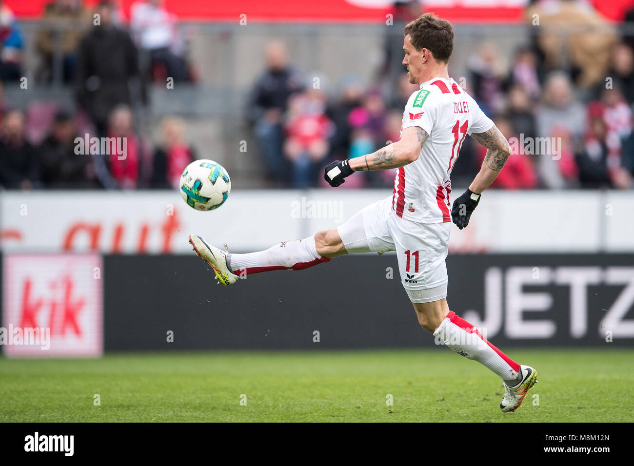 18 March 2018, Germany, Cologne: Football, Bundesliga, 1. FC Cologne vs Bayer Leverkusen at the RheinEnergieStadion. Cologne's Simon Zoller lobs the ball over Leverkusen goalie Leno. Photo: Marius Becker/dpa - WICHTIGER HINWEIS: Aufgrund der Akkreditierungsbestimmungen der DFL ist die Publikation und Weiterverwertung im Internet und in Online-Medien während des Spiels auf insgesamt fünfzehn Bilder pro Spiel begrenzt. Stock Photo