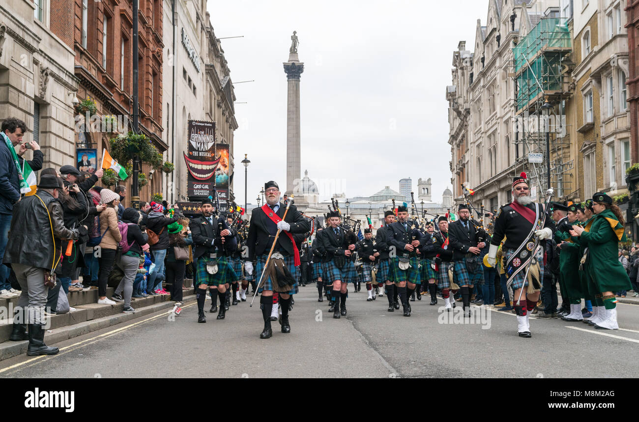 London, UK. 18 March 2018. People celebrating St Patrick's parade during a cold day in London. Bagpipe orchestra marching in Trafalgar Square. Credit: AndKa/Alamy Live News Stock Photo