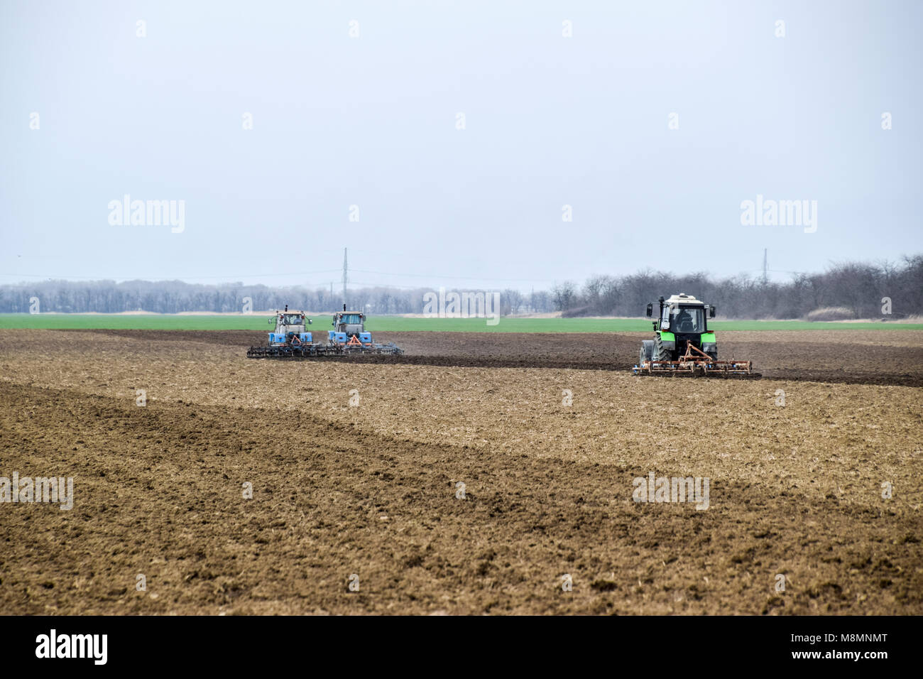 Lush and loosen the soil on the field before sowing. The tractor plows ...