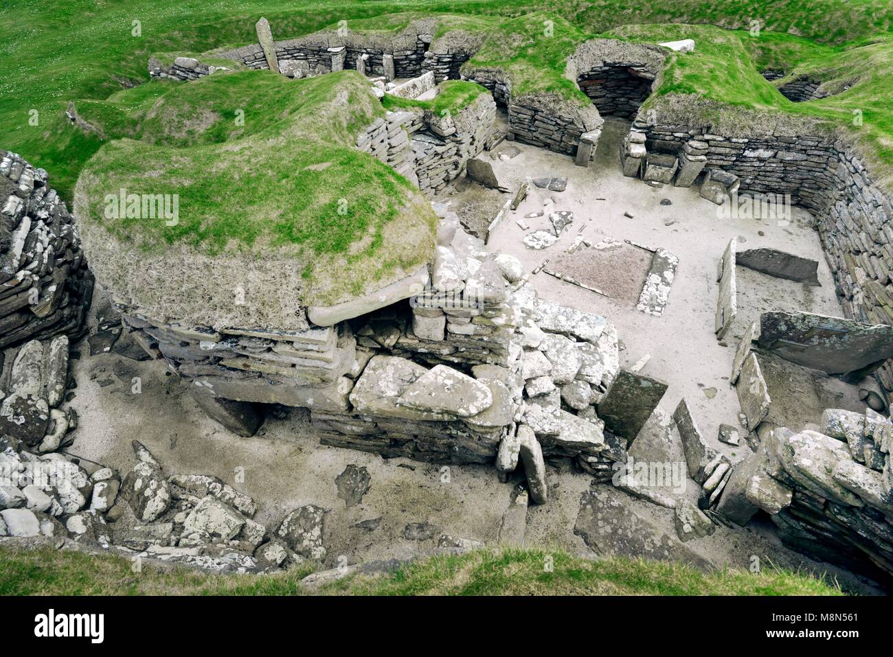 Skara Brae Stone Age Neolithic village at Skaill, Orkney, Scotland. Interior, box beds, hearth and cupboards 3100 BC. House 5 with house 4 behind left Stock Photo