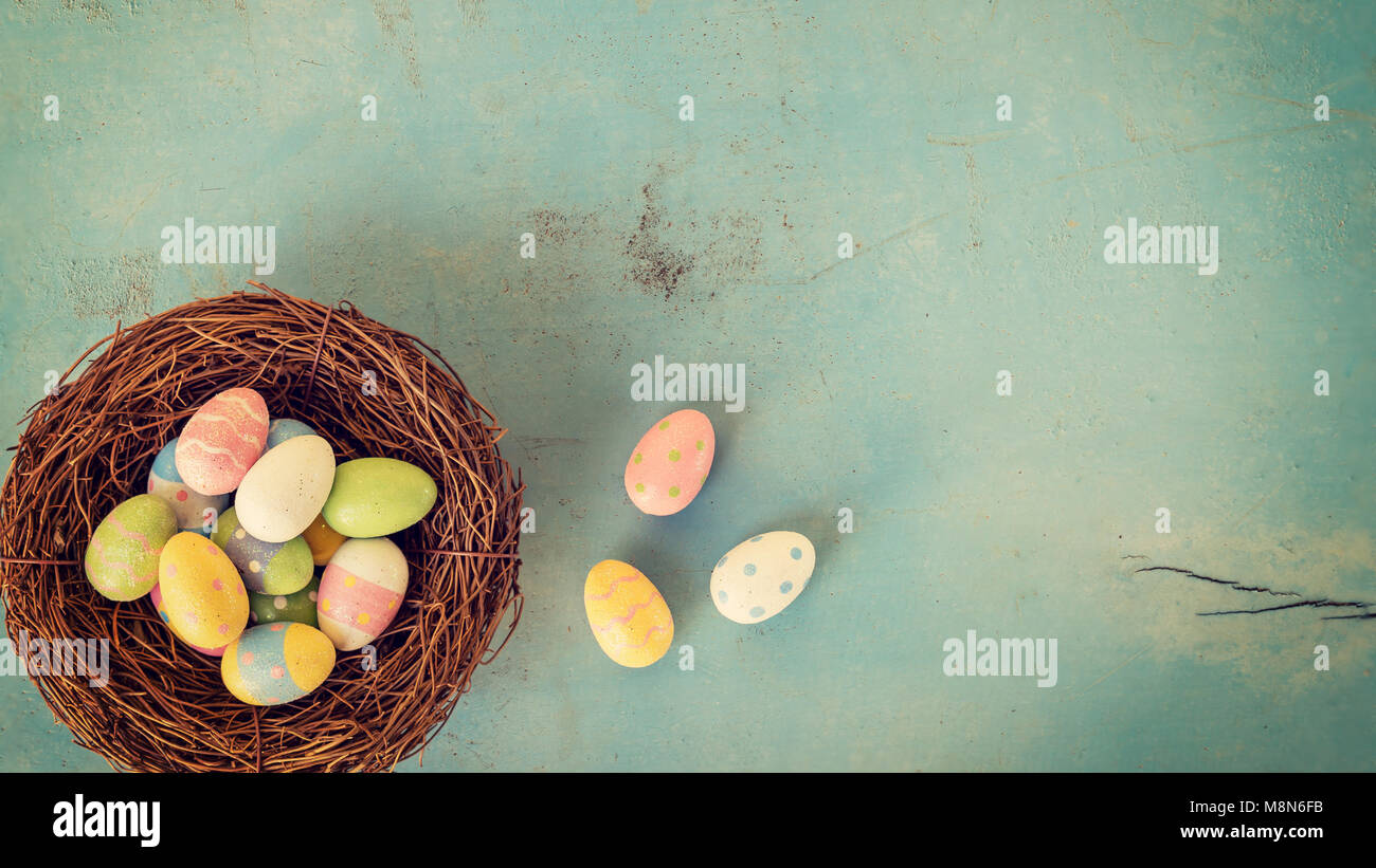 Colorful easter eggs in nest on wood pastel color background with space ...