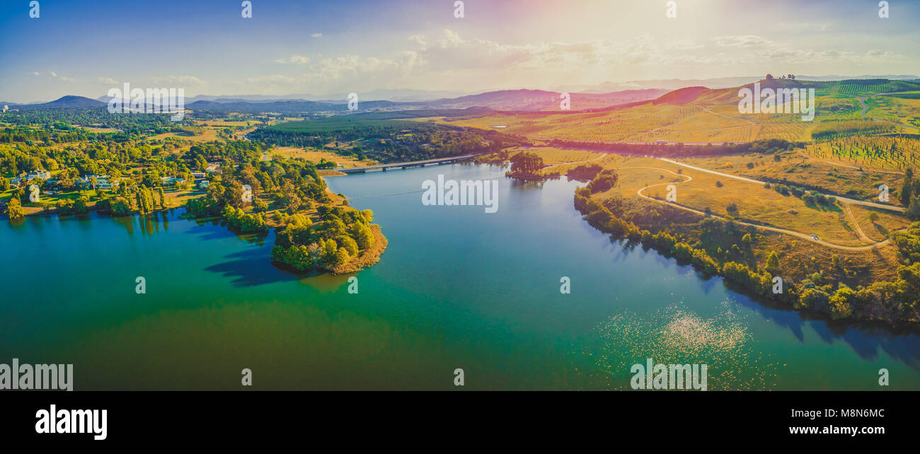 Aerial panorama of beautiful lake and countryside at sunset in Canberra, Australia Stock Photo