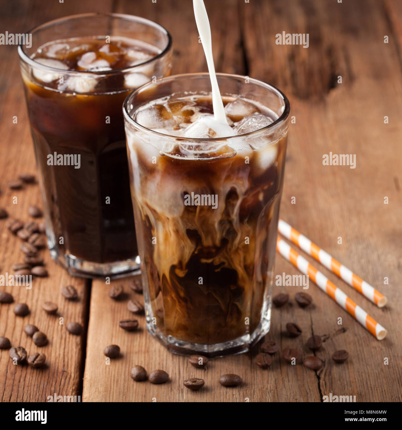 https://c8.alamy.com/comp/M8N6MW/ice-coffee-in-a-tall-glass-with-cream-poured-over-and-coffee-beans-M8N6MW.jpg