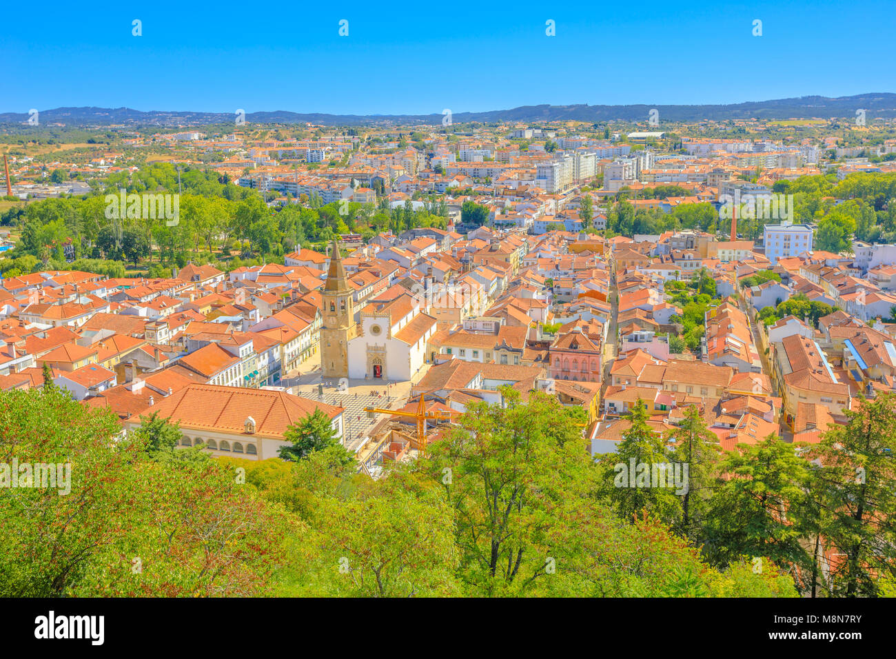 Aerial view of Tomar cityscape and Praca da Republica, the main square with Town Hall and Church of Saint John the Baptist, from Tomar Castle, Portugal, Europe. Tomar city skyline. Blue sky. Stock Photo