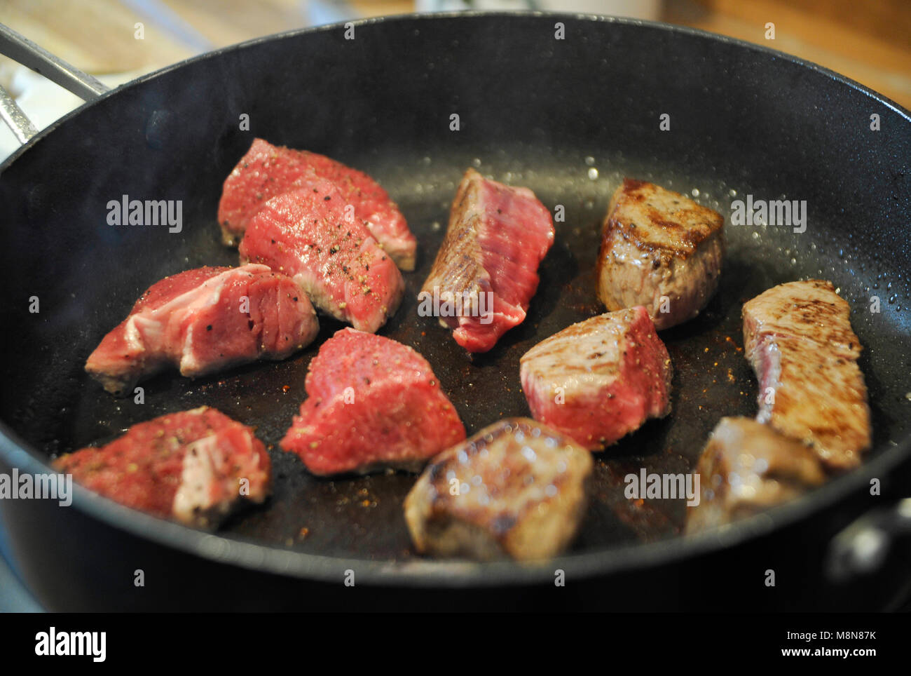 Browning off Aberdeen Angus beef steak meat in frying pan for a casserole Stock Photo