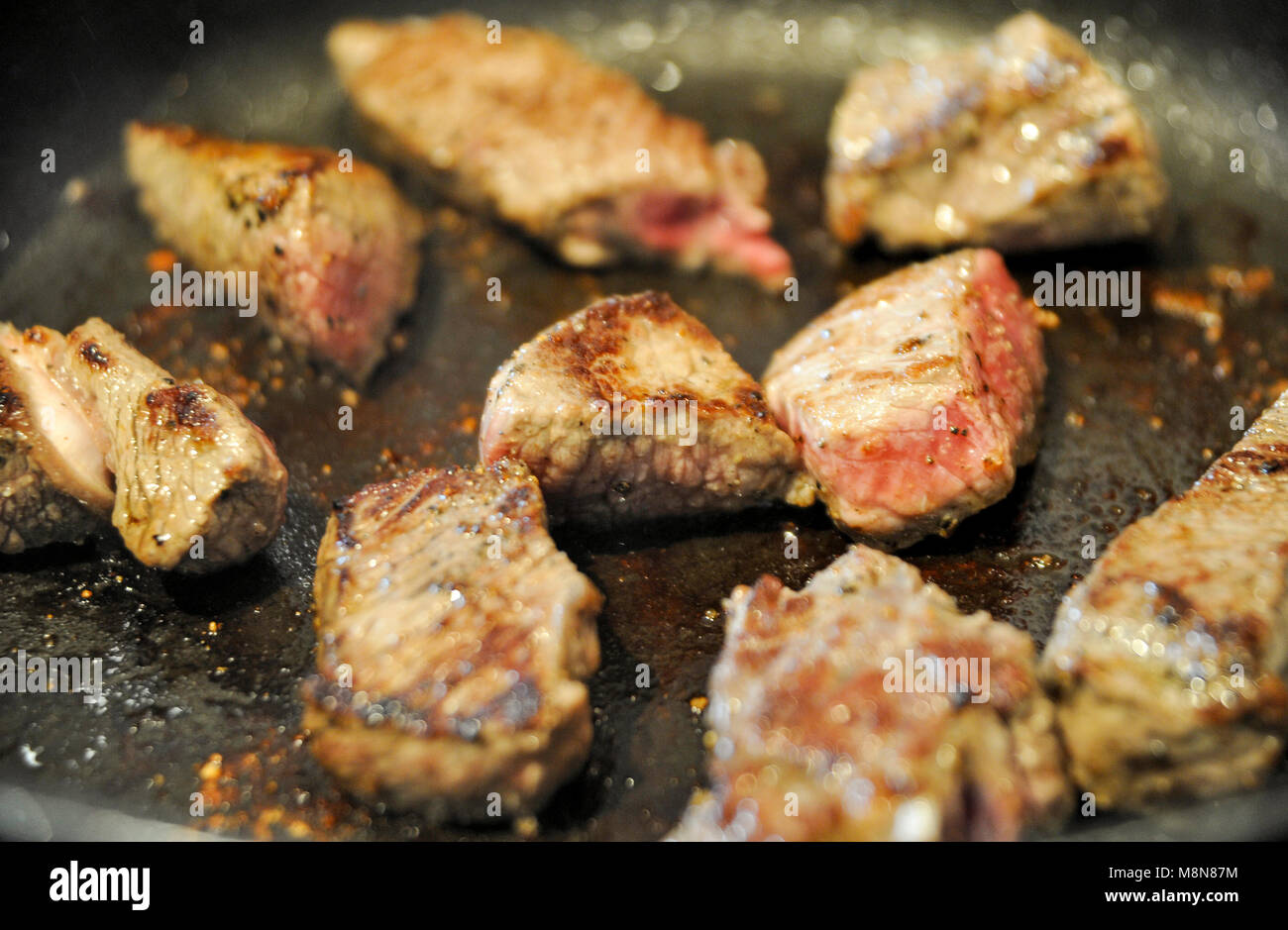 Browning off Aberdeen Angus beef steak meat in frying pan for a casserole Photograph taken by Simon Dack Stock Photo