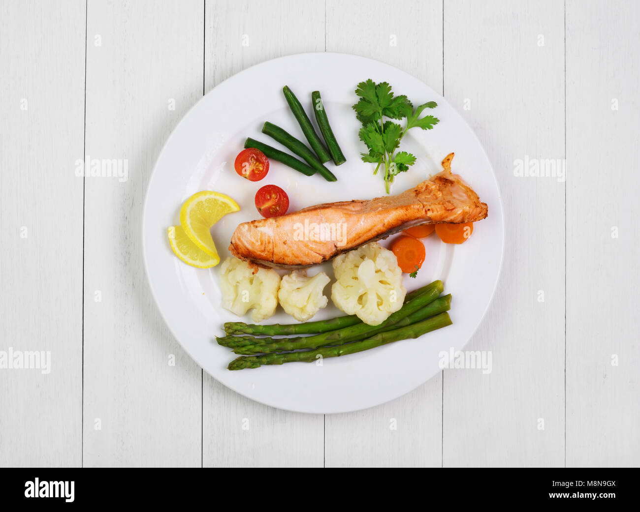 Grilled salmon with vegetables on  white old wooden rustic table. Top view Stock Photo