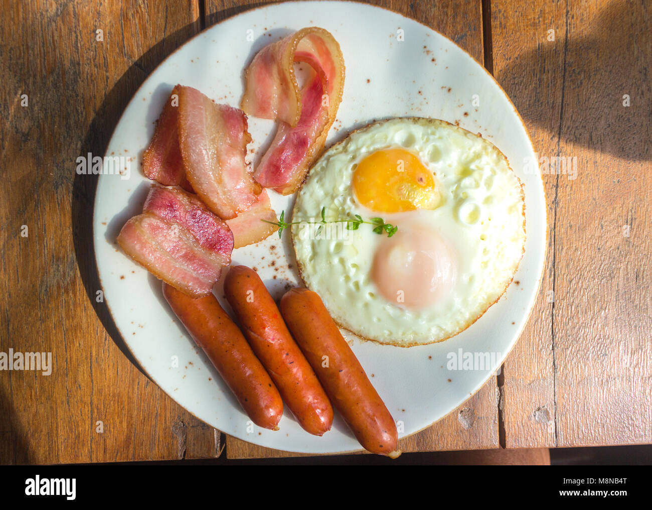 Set of american breakfast with bacon, fried eggs and sausage on wood table background Stock Photo