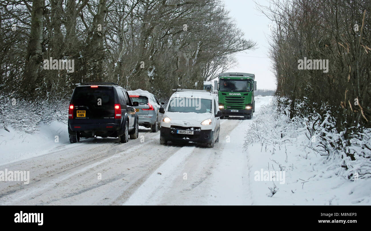 Vehicles are driven along a snow covered road near Okehampton in Devon. The A30 was hit by 'significant snow' overnight, Devon and Cornwall Police said, with conditions 'changing rapidly from passable to impossible'. Some 64 miles of road between the M5 at Exeter and the A38 at Bodmin were shut as a result while officers and Highways England cleared the route. Stock Photo