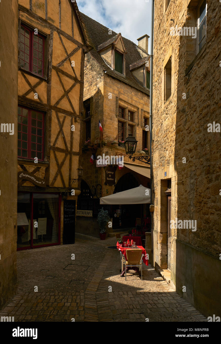 An outdoor table for two in the medieval town of Sarlat la Caneda in the Perigord Noir region of the Dordogne France. Stock Photo