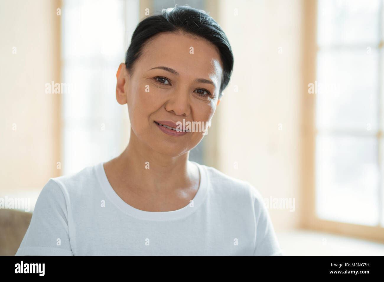 Beautiful pleased woman smiling sincerely Stock Photo