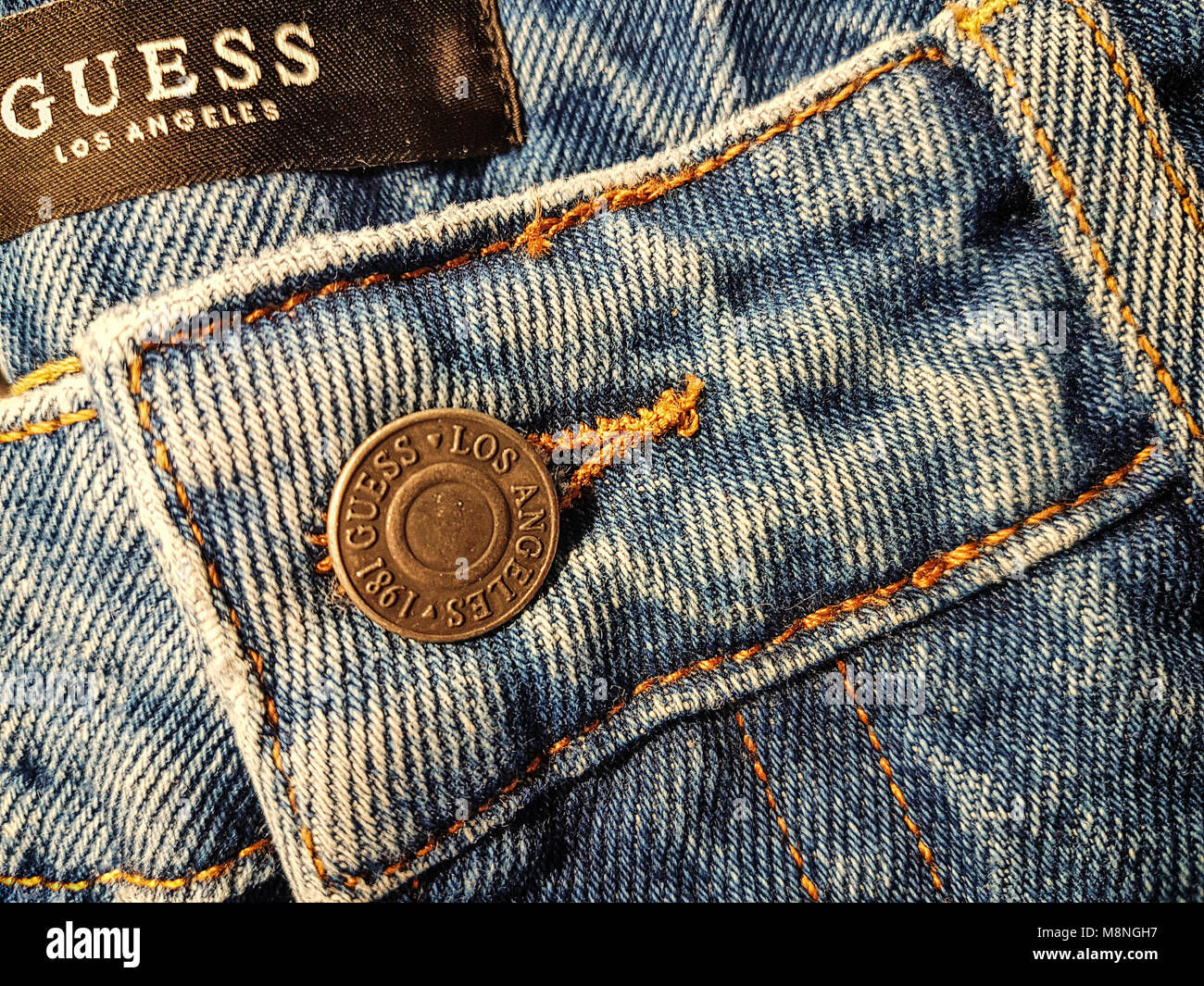 Krakow, Poland - February 21, 2018: Close-up of the Guess jeans button and front details.  Guess is a famous American clothing brand and retailer foun Stock Photo