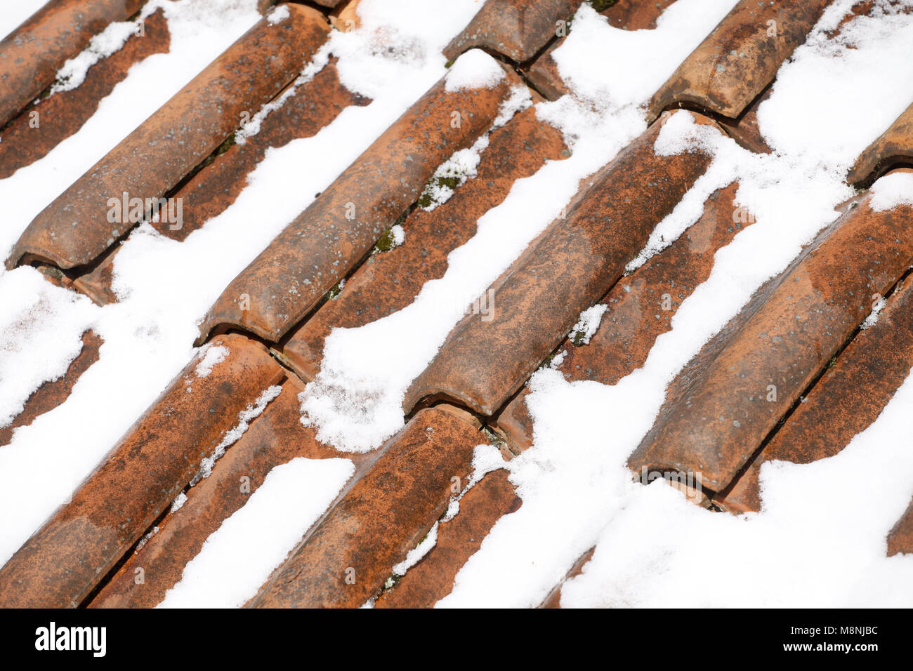 Roof tiles with recent snow fall covering them in winter Stock Photo