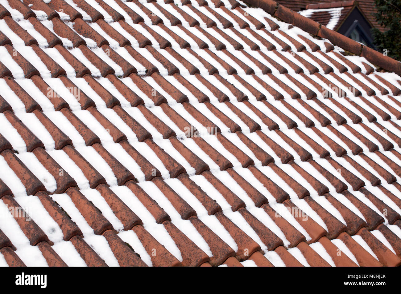 Roof tiles with recent snow fall covering them in winter Stock Photo