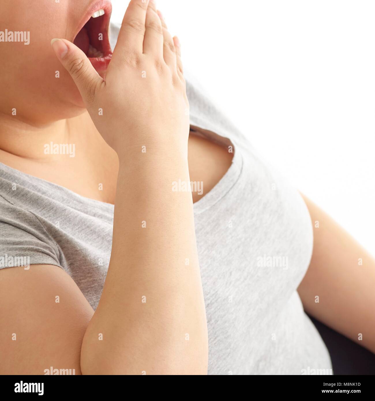 Woman yawning with hand over mouth. Stock Photo