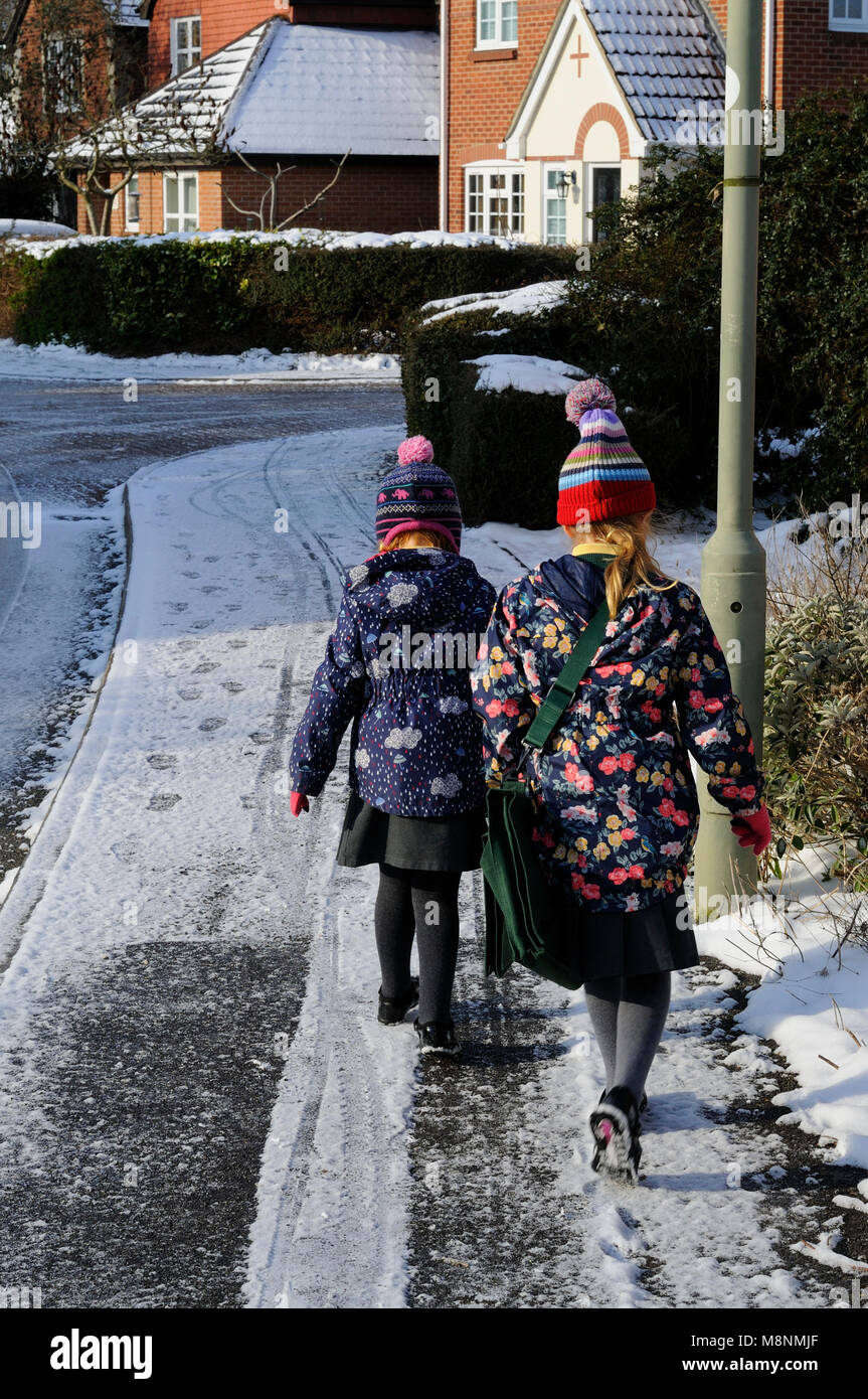 Two girls walking to school in the snow Stock Photo