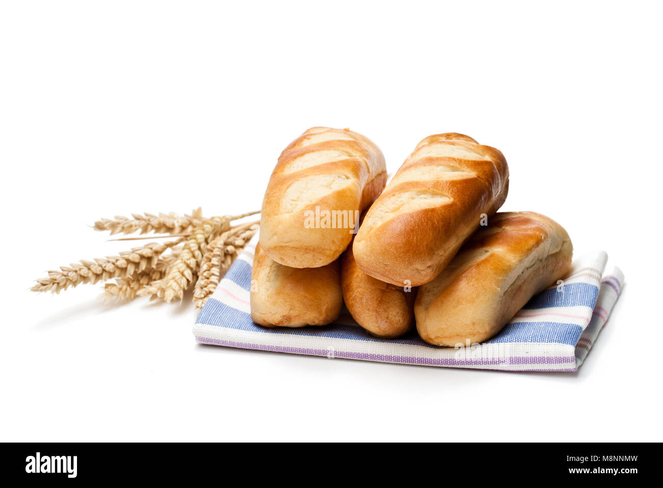 Mini loaf bread on rustic towel and wheat ears isolated on white ...