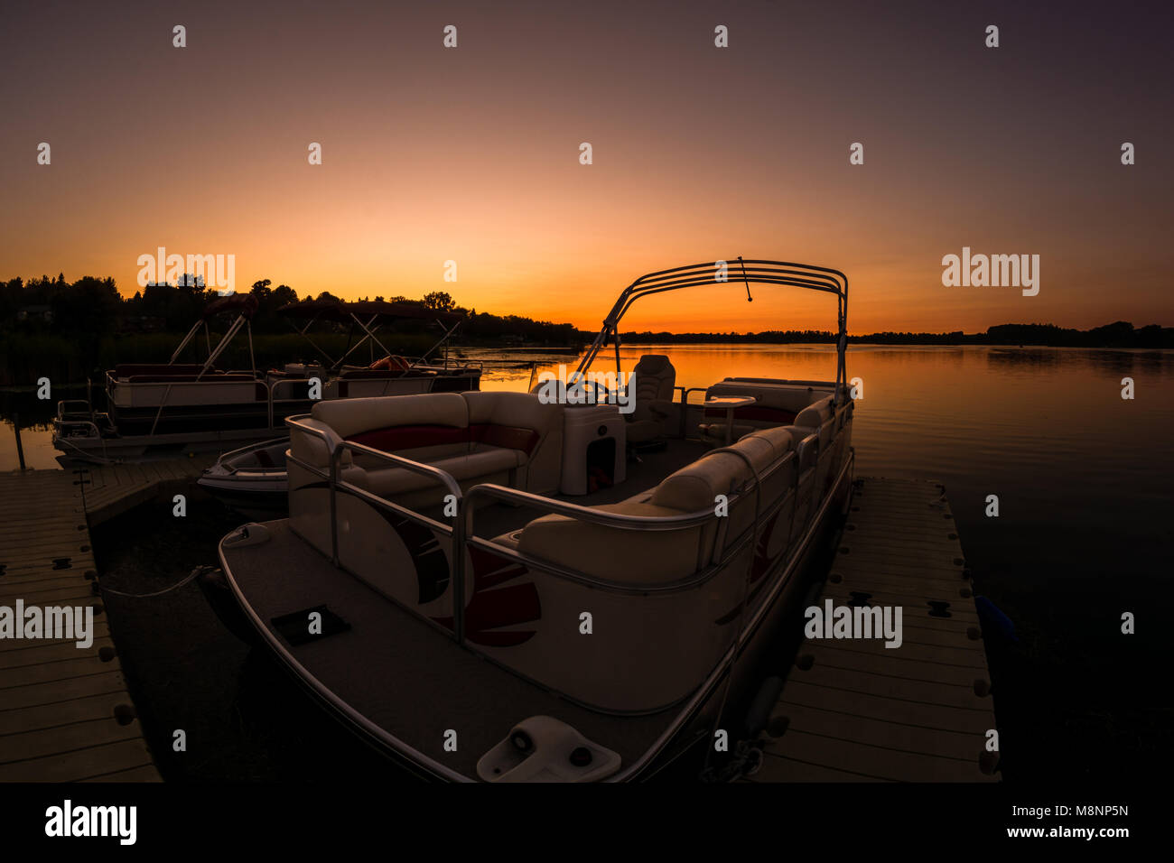 Pontoon boat with lake sunset background Stock Photo - Alamy