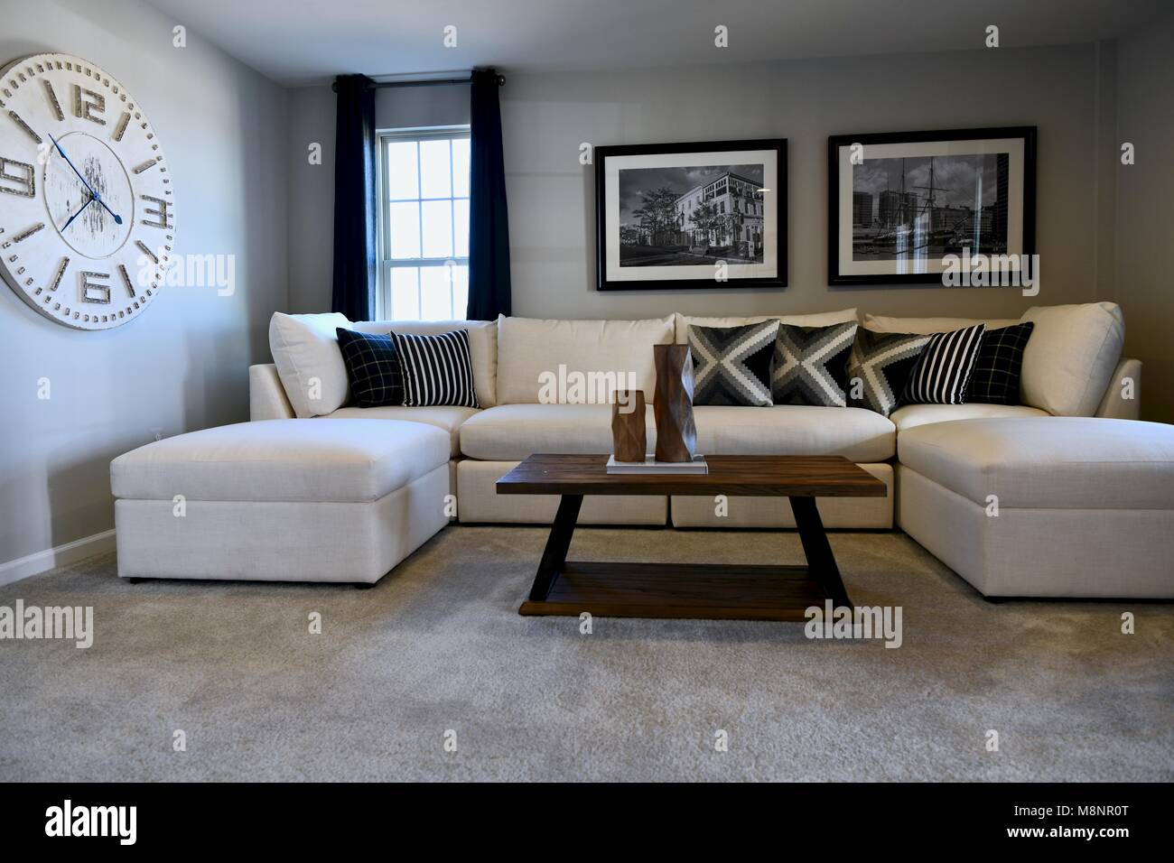 Living room with white sectional and modern decor on the walls Stock Photo