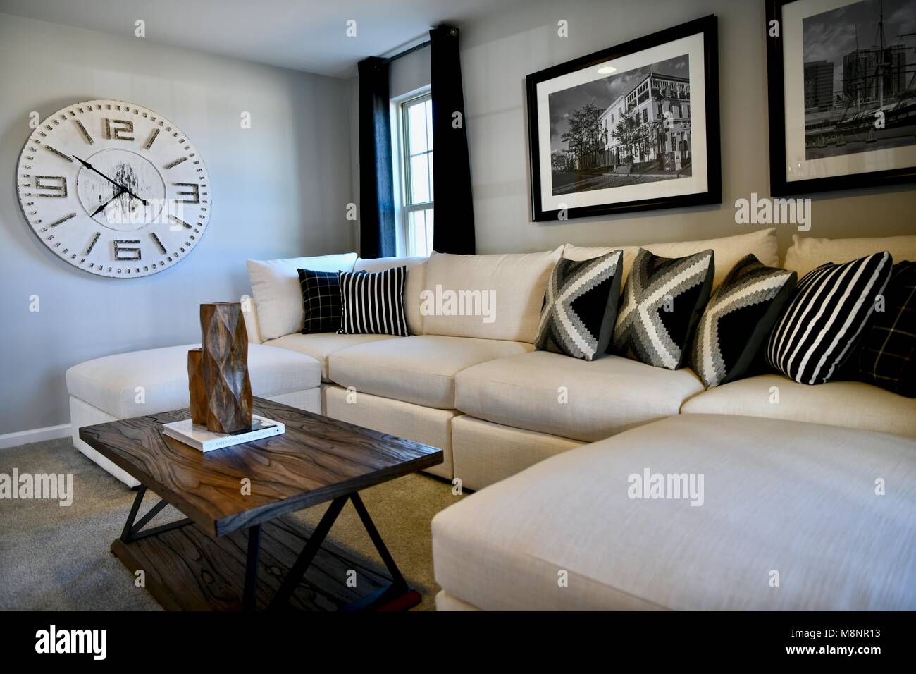 Living room with white sectional and modern decor on the walls Stock Photo