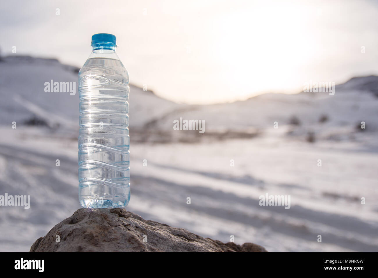Water bottle with snowy mountain peak background. Empty space for your text. Stock Photo