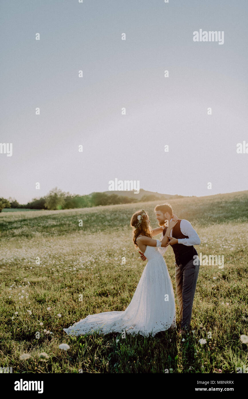 Beautiful bride and groom at sunset in green nature Stock Photo - Alamy