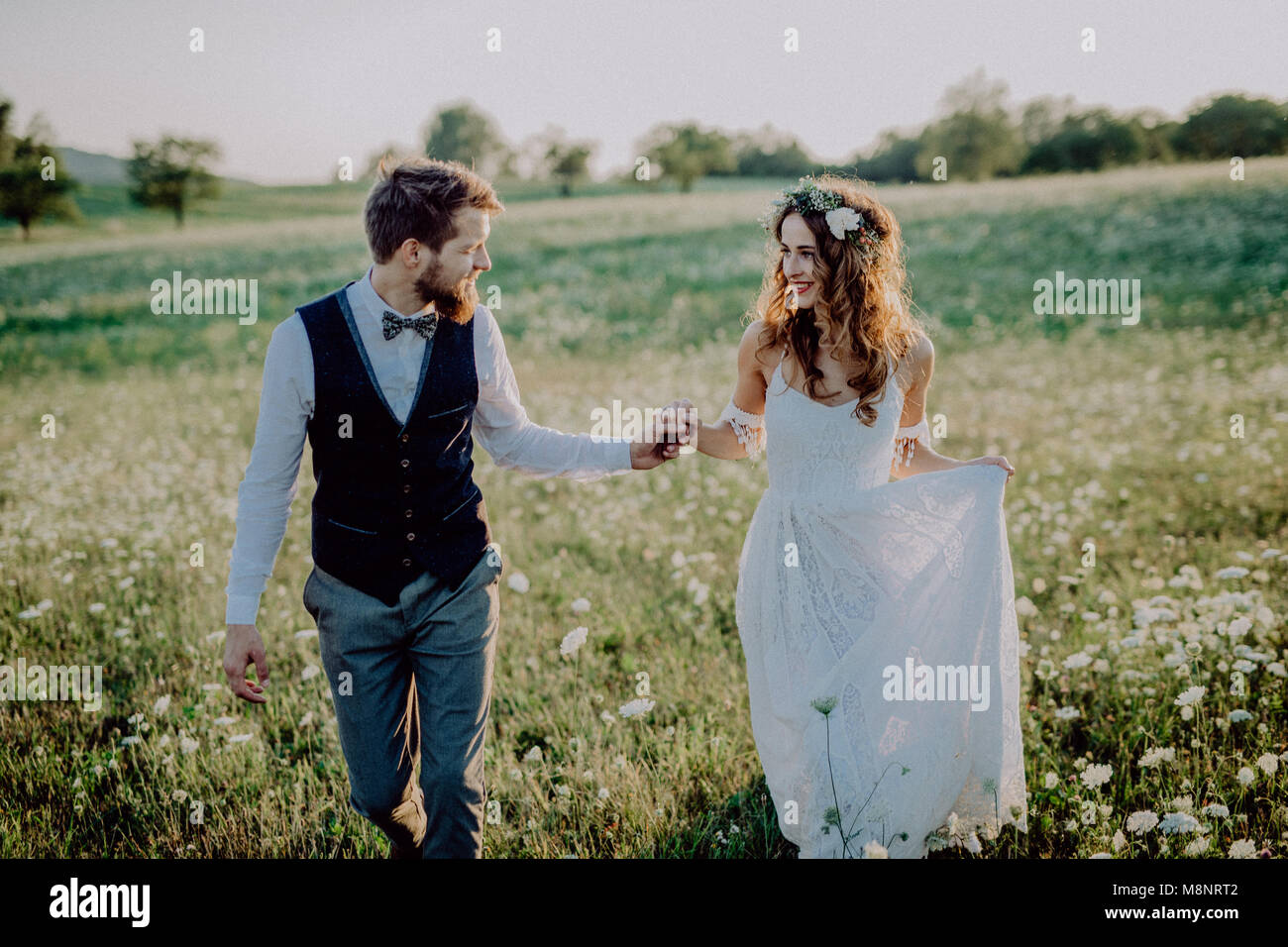 Beautiful bride and groom at sunset in green nature Stock Photo - Alamy
