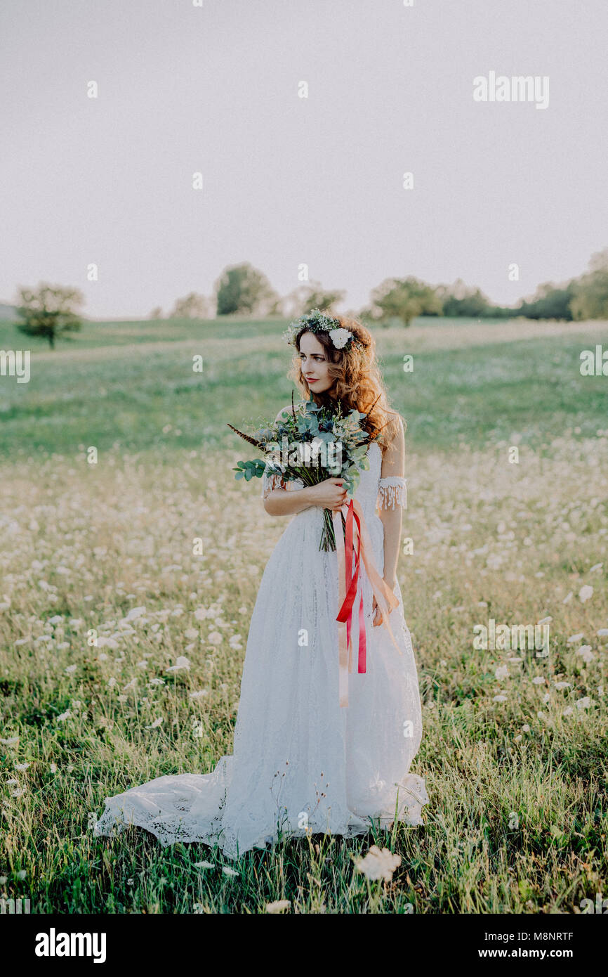 Beautiful young bride at sunset in green nature Stock Photo - Alamy